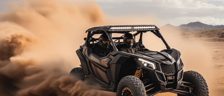 A black 4-seat side-by-side off-road vehicle driving through a desert landscape.