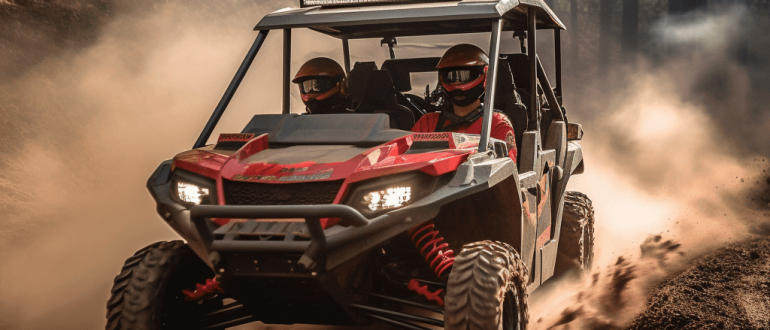 a red 4-seat side-by-side utility terrain vehicle driving down a dirt road through a forest.
